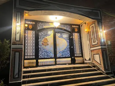 a building with a glass door with stairs in front at Luxor Hostel Place in Al Baghdādī