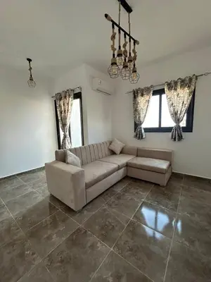a living room with a couch and two windows at Aqua Infinity Hurghada in Hurghada