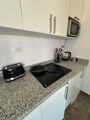 a kitchen counter with a stove and a microwave at Aqua Infinity Hurghada in Hurghada