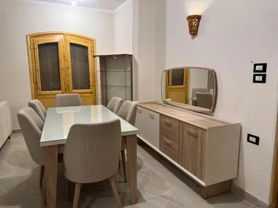 a dining room with a table and a tv at Pharaohs Apartments - Panoramic Fourth Floor Apartment in Luxor