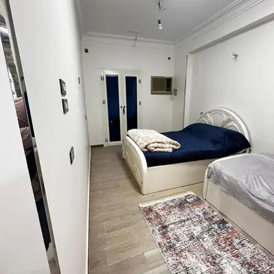 a small bedroom with two beds and a rug at FUN MBASSY DELUXE APARTMENT ASWAN down town in Aswan