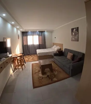 a living room with a couch and a bed at Sea La Vie Furnteched, Central, Beach Front, Free WIFI in Hurghada