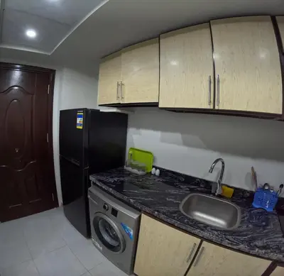 a small kitchen with a sink and a refrigerator at Sea La Vie Furnteched, Central, Beach Front, Free WIFI in Hurghada