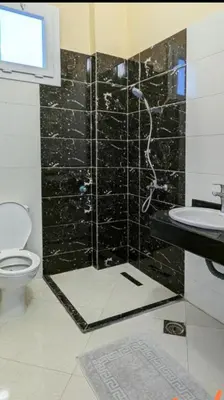 a bathroom with a shower with a toilet and a sink at Karima's house B in Al Aqālitah