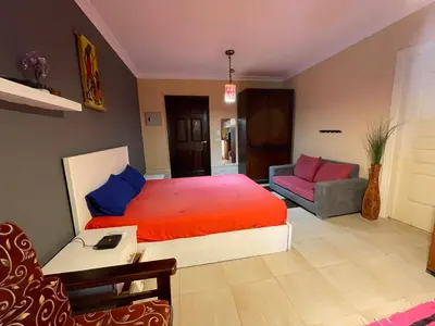 a bedroom with a large bed and a couch at Family-Friendly Studio, Beach and Pools Access in Hurghada