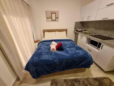 a bed in a small room with a blue blanket at Aqua Palms Resort Hurghada in Hurghada