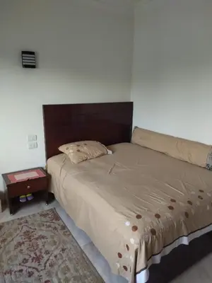 a bedroom with a large bed with a wooden headboard at Luxor Resort in Al Bayāḑīyah