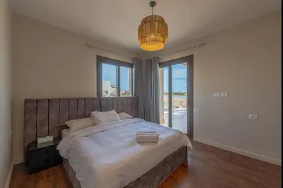 a bedroom with a large bed with a large window at Stunning Villa with breathtaking golf & lake view in Hurghada