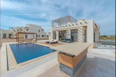 a house with a swimming pool in front of a house at Stunning Villa with breathtaking golf & lake view in Hurghada