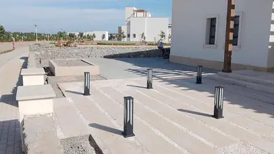 a row of posts on a sidewalk next to a building at Stunning Villa with breathtaking golf & lake view in Hurghada