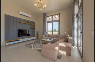 a living room with a couch and a tv at Stunning Villa with breathtaking golf & lake view in Hurghada