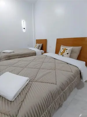 two beds in a white room with at Desert Daisy in Luxor