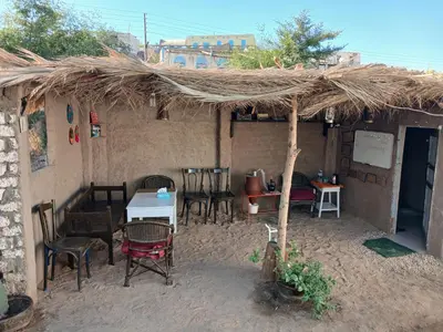 a restaurant with a table and chairs and a straw roof at Soul house in Aswan