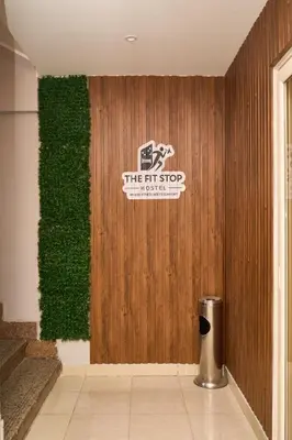 a room with a green wall with a sign on it at The Fit Stop Hostel in Hurghada