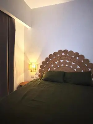a bedroom with a bed with a wooden headboard at EL GOUNA Boho Beach Chalet with pool access in Hurghada
