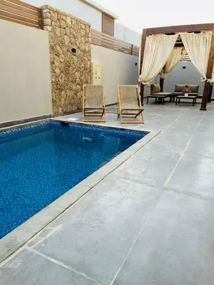 two chairs and a swimming pool in a house at 2BR Ground Floor Apartment with Heated Pool in Bali El Gouna in Hurghada