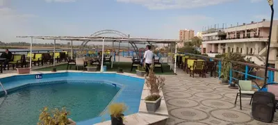 a person standing next to a swimming pool on a building at فندق نايل ايليت سوهاج in Qilfāw