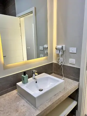 a bathroom with a white sink and a mirror at Cyan Lakefront 3BR Townhouse El Gouna in Hurghada