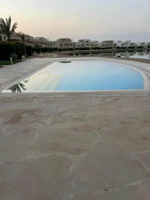 a large swimming pool with a building in the background at Cyan Lakefront 3BR Townhouse El Gouna in Hurghada