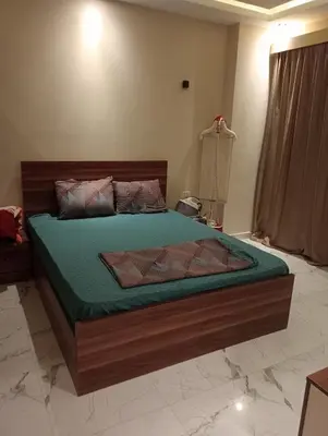 a bedroom with a bed with a green comforter at Luxury Flat 3 rooms in Hurghada