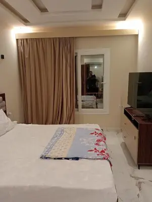 a bedroom with a bed and a tv and a window at Luxury Flat 3 rooms in Hurghada