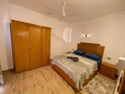 a bedroom with a bed and a wooden cabinet at Anubis Guesthouse in Luxor