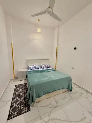 a bedroom with a bed and a ceiling fan at Anubis Guesthouse in Luxor
