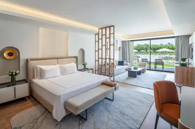 a bedroom with a large bed and a living room at Rixos Premium Magawish Bay View in Hurghada