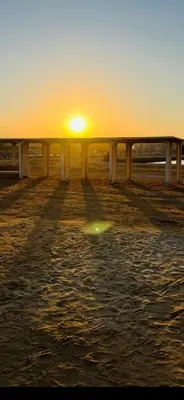 a sunset over a pier with the sun in the distance at Princess Resort Lovely Studio in Hurghada