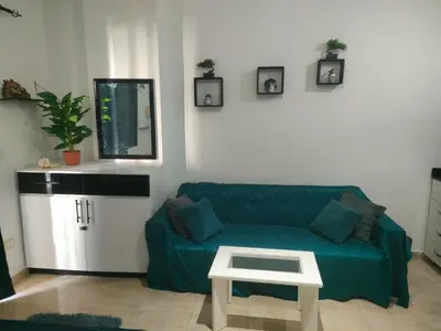 a living room with a green couch and a table at Sherathon studio Pavel in Hurghada