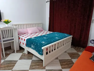 a bedroom with a white bed with a blue blanket at Sherathon studio Sheri in Hurghada