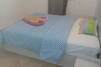 a bed with a blue and white comforter with a toy on it at Beachfront 3-Bed Sleeps 6 with Sea View in Hurghada