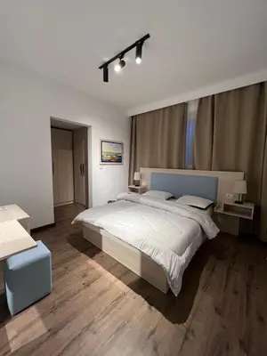 a bedroom with a large white bed and wooden floors at Sholan El Gouna 2 Bedroom Apartment in Hurghada