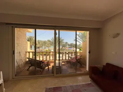 a room with a sliding glass door with a view of a porch at cozy sea view apartment palma resort in Hurghada