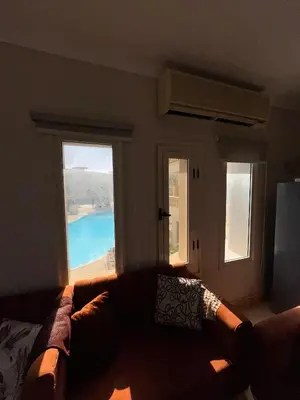 a living room with a couch and two windows at cozy sea view apartment palma resort in Hurghada