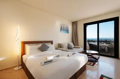 a bedroom with two beds and a large window at Tranquil Terrace Studio at Ancient Sands in Hurghada