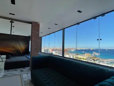 a living room with a couch in front of a large window at Sea view Penthouse sea front city center 11 in Hurghada