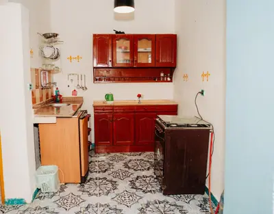 a kitchen with red cabinets and a tile floor at Harmonia House in Al Karnak