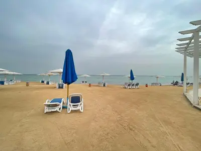 a group of chairs and umbrellas on a beach at Sea-Front Selena Bay Resort Apartment in Hurghada