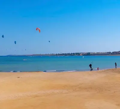 a group of people on a beach flying a kite at Amazing 1 bedroom & sofa bed at Selenabay Hurghada in Hurghada