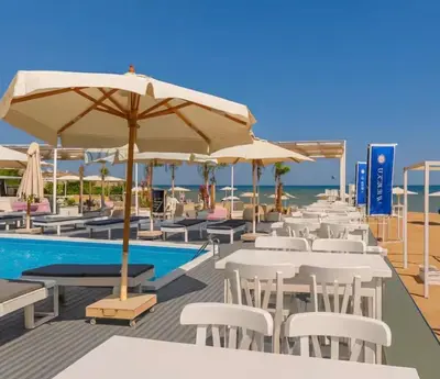 a row of tables and umbrellas next to a swimming pool at Amazing 1 bedroom & sofa bed at Selenabay Hurghada in Hurghada