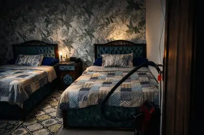 a bedroom with two beds in a room with wallpaper at Tiba Golden in Hurghada