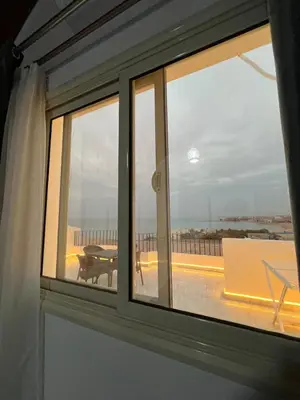 a window with a view of a balcony with a table at Luxury Sea-View Rooftop with Private Terrace in Hurghada