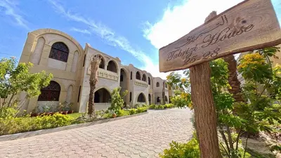 a sign in front of a building with a street at Saray El Omda - Egyptian Rural Village in Luxor