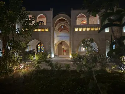 a building with arches and a courtyard at night at Saray El Omda - Egyptian Rural Village in Luxor