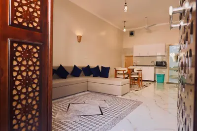 a living room with a couch and a kitchen at Luxor Hermes Guest House in Luxor