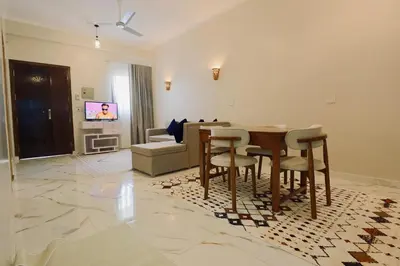 a living room with a wooden table and chairs at Luxor Hermes Guest House in Luxor