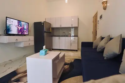 a living room with a blue couch and a tv at Luxor Hermes Guest House in Luxor