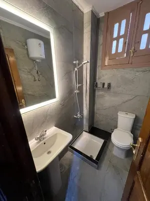 a bathroom with a sink and a toilet and a mirror at 3 bedroom duplex in Hurghada