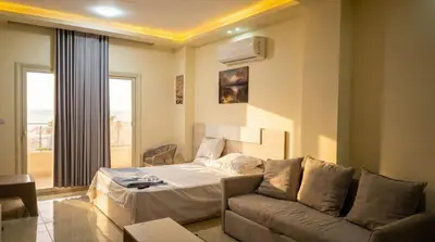 a living room with a couch and a bed at Seaside studio with private Beach and pool in Hurghada